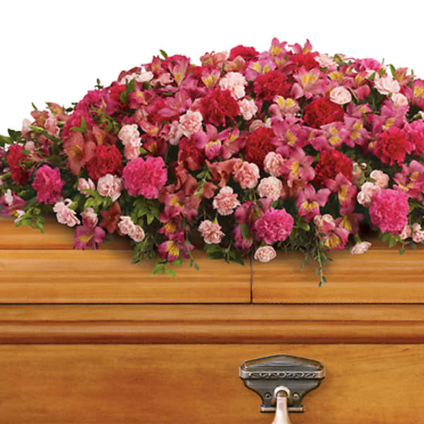 Pink and red floral spray on a wooden casket