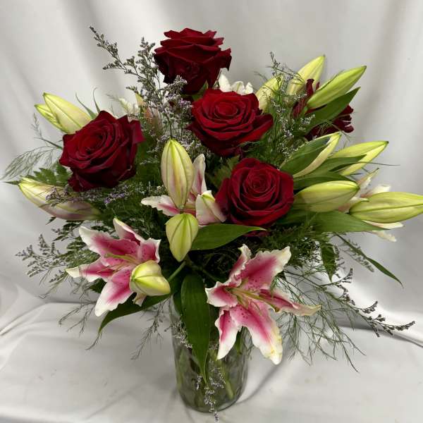 Bouquet of red roses and pink lilies in a glass vase