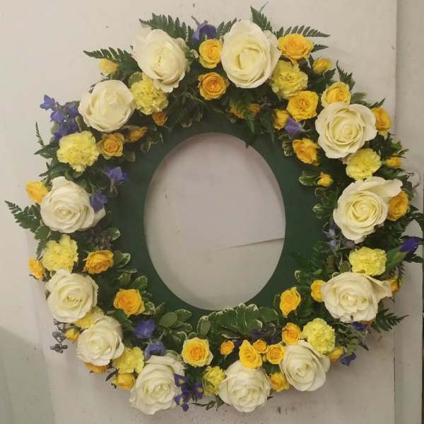 Circular floral wreath with white, yellow, and purple flowers