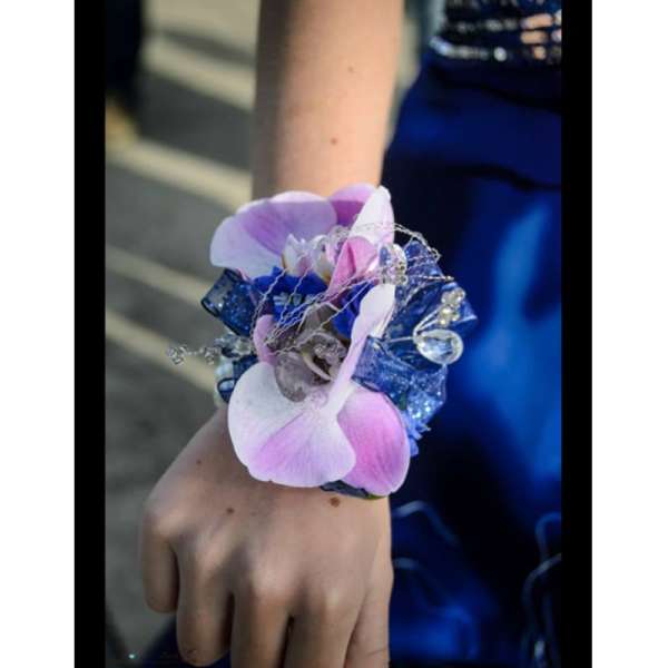 Pink and white orchid wrist corsage with blue ribbon and rhinestone accents