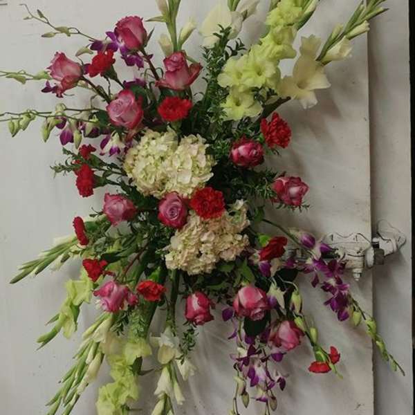 Tall mixed floral spray with pink, red, white, and purple blooms