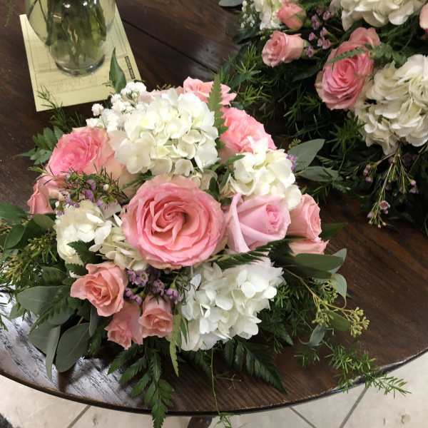 Pink roses and white hydrangeas arranged on a table
