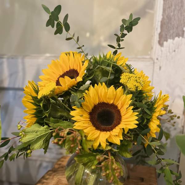 Sunflower arrangement in a round glass vase