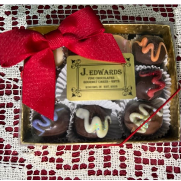 Box of assorted chocolates with a red ribbon bow