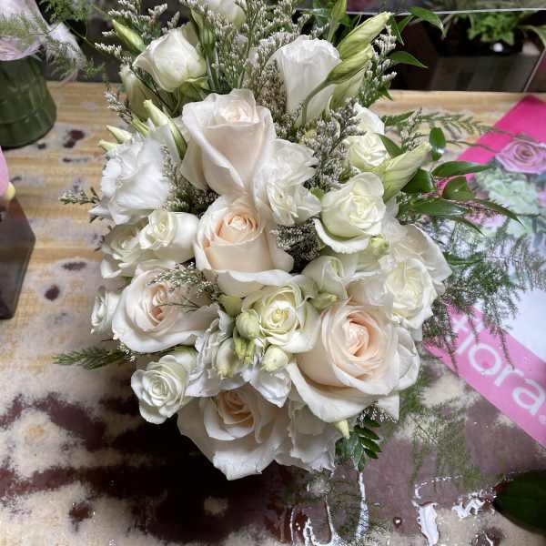 Bouquet of white and blush roses with white lisianthus and greenery