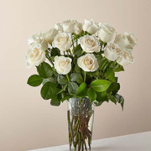 White roses arranged in a clear glass vase