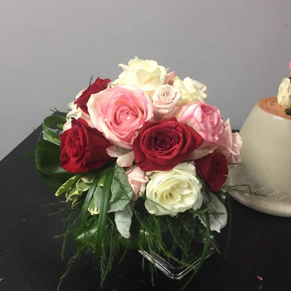 Bouquet of pink, red, and white roses in a low glass vase