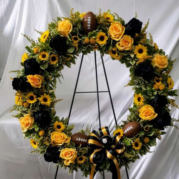 Football-themed floral wreath with yellow roses and sunflowers
