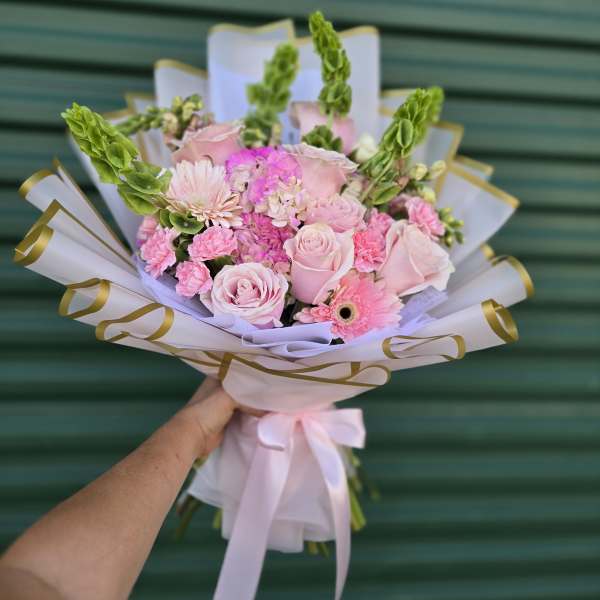 Pink rose bouquet with gerbera daisies and carnations wrapped in white paper