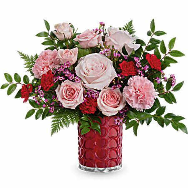 Pink and red flower arrangement in a red glass vase
