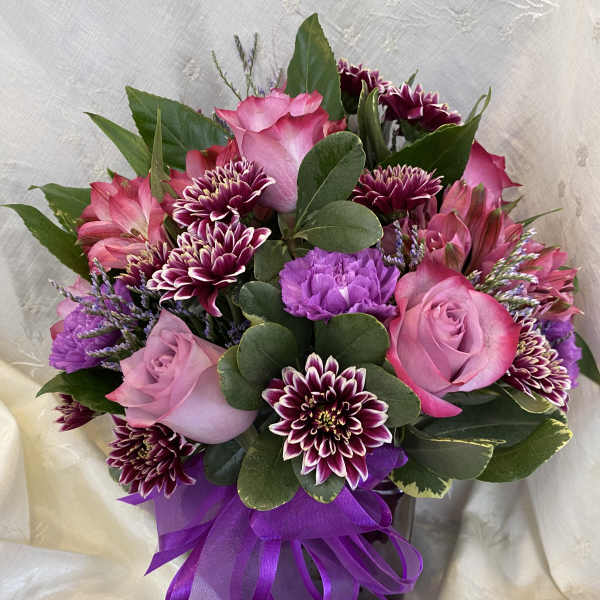 Pink and purple bouquet with roses and chrysanthemums tied with a purple ribbon