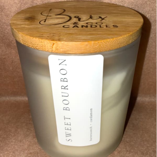 Frosted glass candle jar with a bamboo lid and label