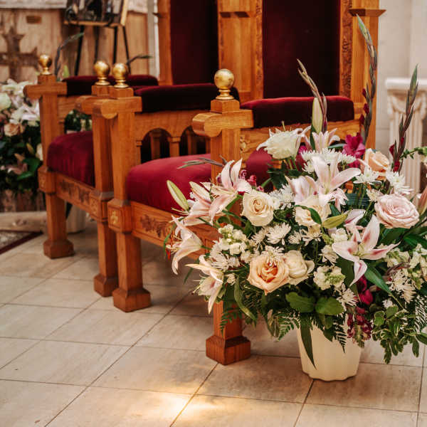Large floral arrangement with lilies and roses in a church interior