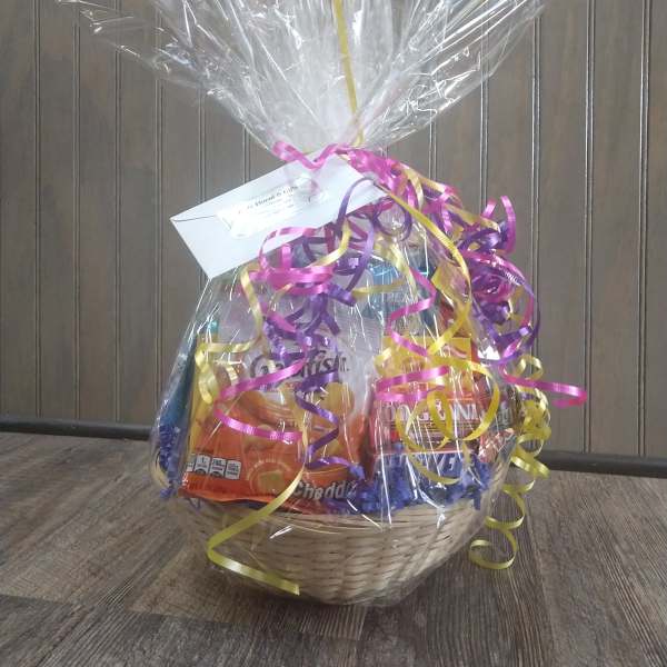 Gift basket with assorted snacks wrapped in clear cellophane and ribbon