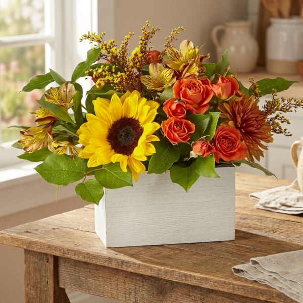 Sunflower and orange rose arrangement in a white wooden box