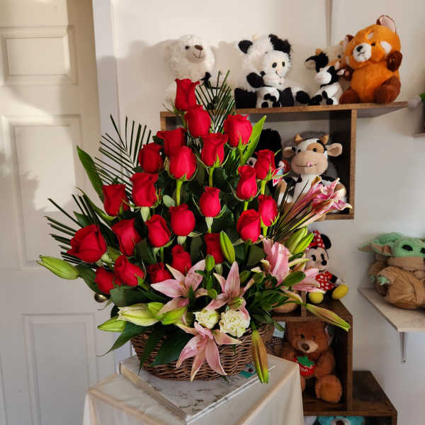Basket arrangement of red roses and pink lilies