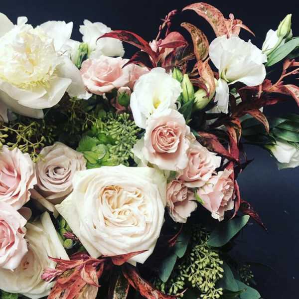 Bouquet of pale pink and white roses with white blooms and dark foliage