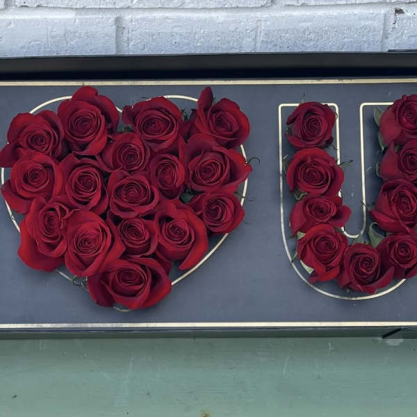 Red roses arranged to spell "I LOVE U" on a sign