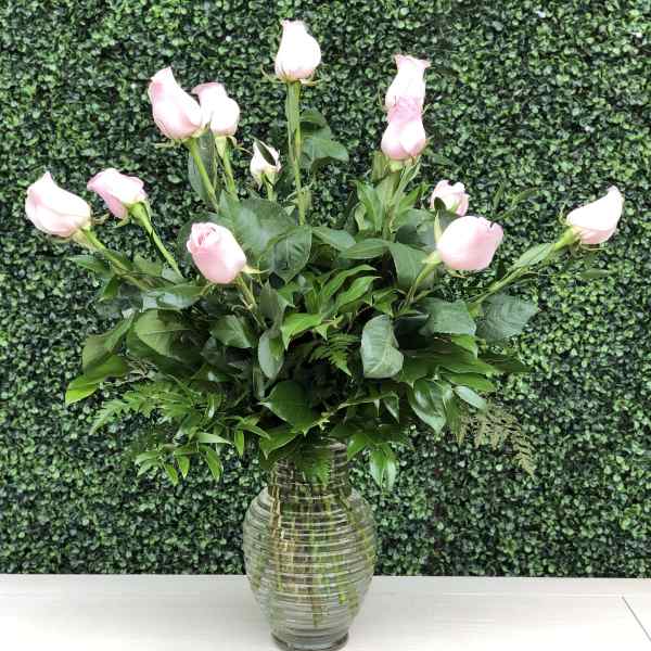 Pink roses arranged in a clear glass vase