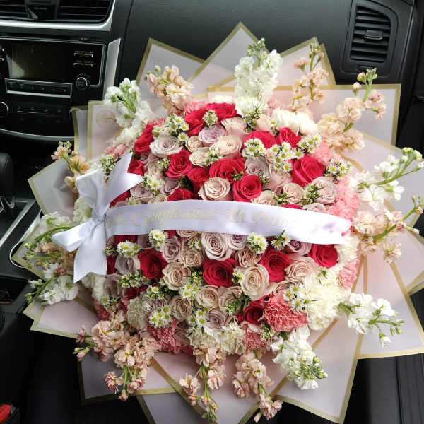 Large bouquet of pink and white roses with small white daisies