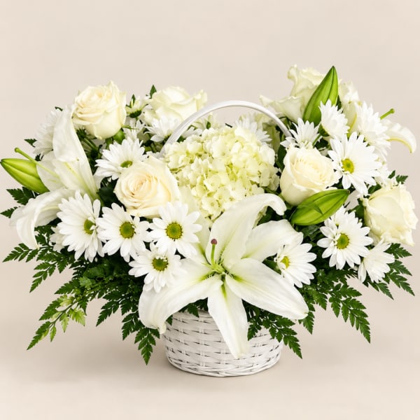 White lilies, roses, and daisies arranged in a white basket