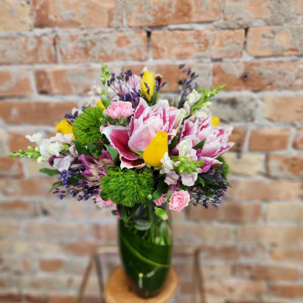 Pink and white bouquet in a green glass vase