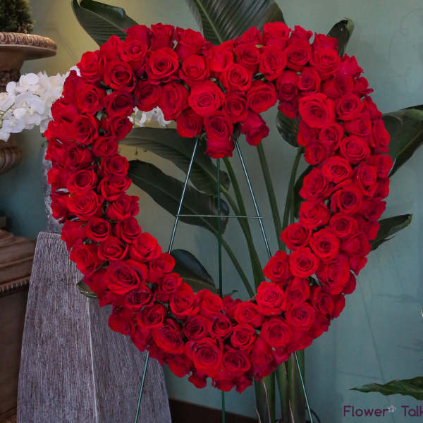 Heart-shaped arrangement of red roses on a stand