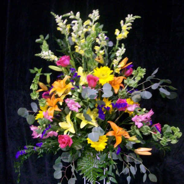 Tall mixed flower arrangement with lilies, roses, and daisies