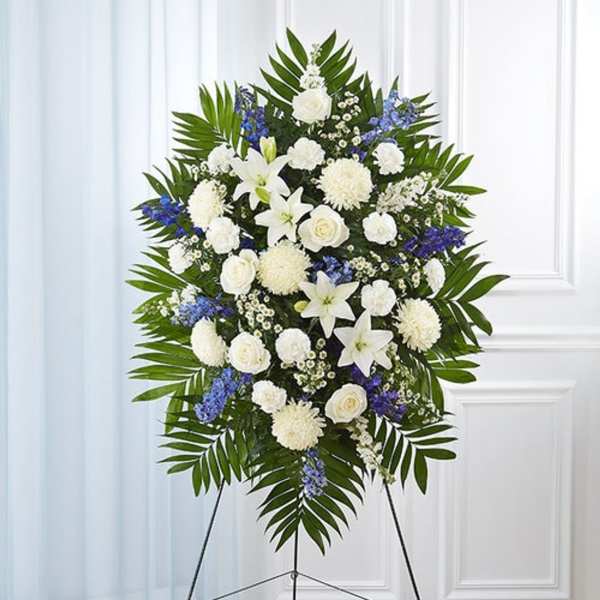 White and blue funeral spray on a standing easel