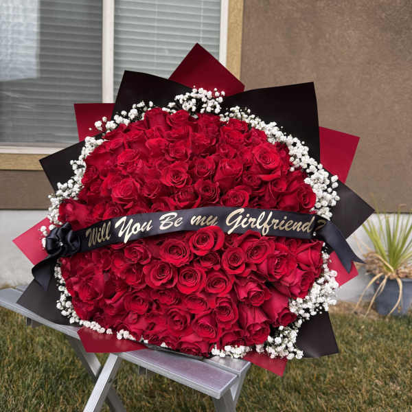 Large bouquet of red roses with white baby's breath and a black ribbon