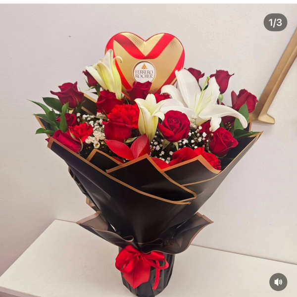 Bouquet of red roses and white lilies with a heart-shaped Ferrero Rocher box