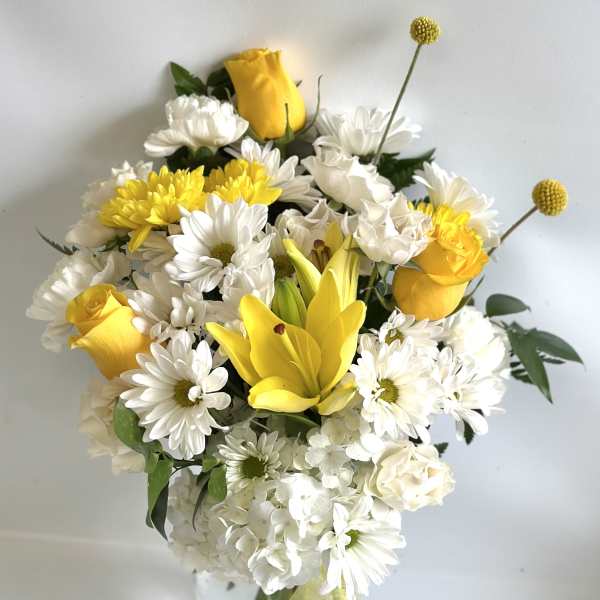 Yellow roses and white daisies in a glass vase