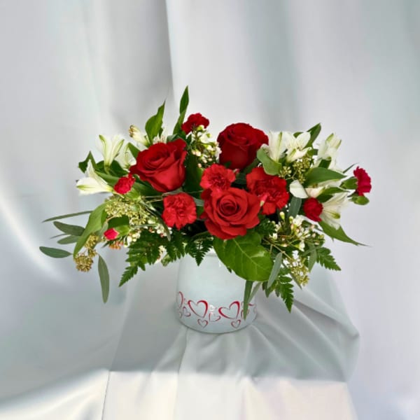 Red roses and white lilies in a heart-decorated vase