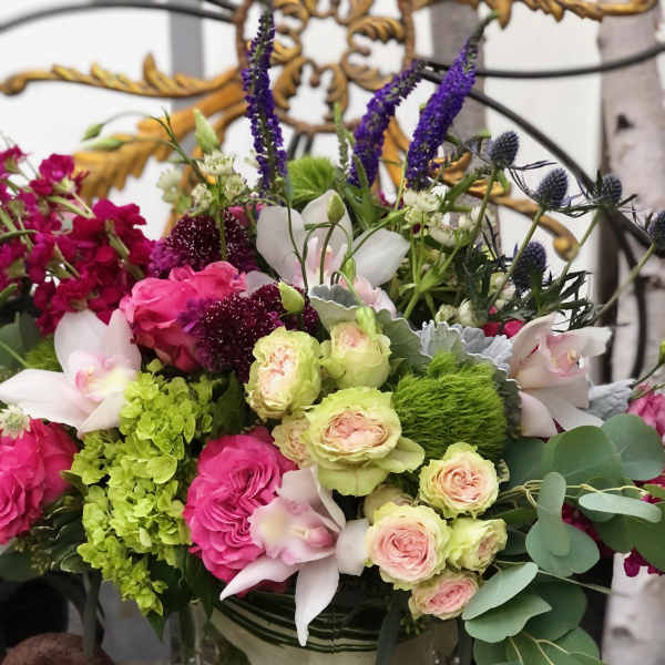 Mixed bouquet in a glass vase with pink, white, green, and purple flowers