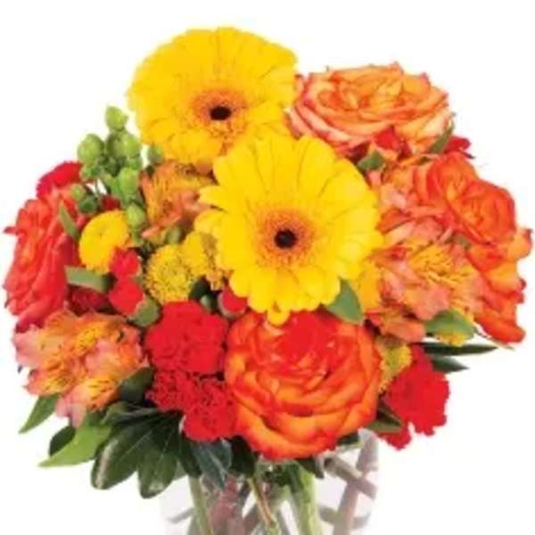 Bouquet of yellow gerbera daisies and orange roses in a clear glass vase