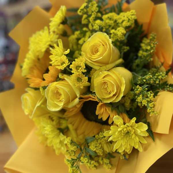Yellow rose and chrysanthemum bouquet wrapped in yellow paper