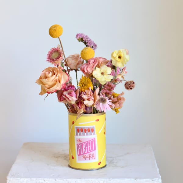 Mixed bouquet in a yellow tin can with pink and yellow flowers