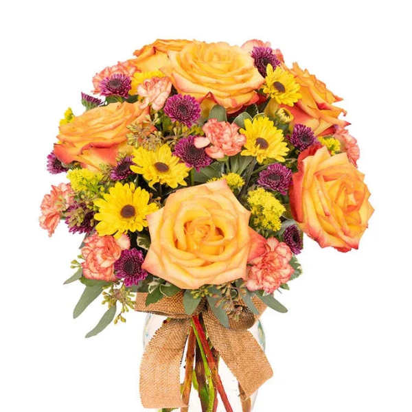 Bouquet of yellow roses, daisies, and pink carnations in a glass vase