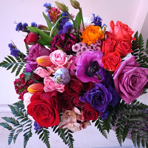 Handheld bouquet of multicolored roses and mixed blooms