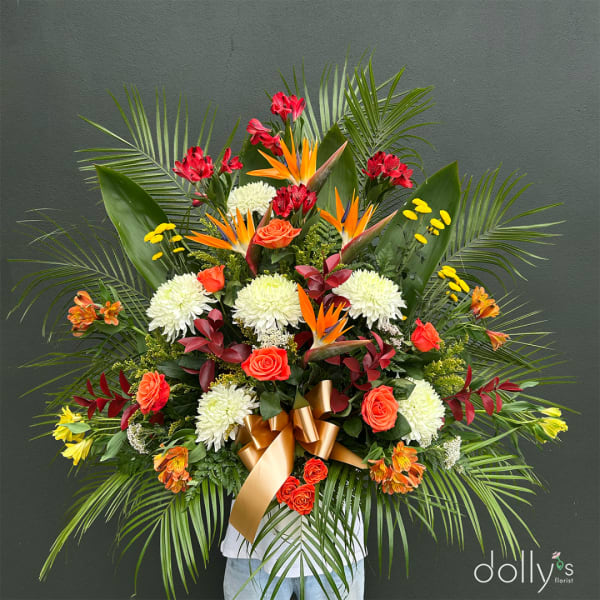 Large tropical floral arrangement with roses, chrysanthemums, and bird-of-paradise