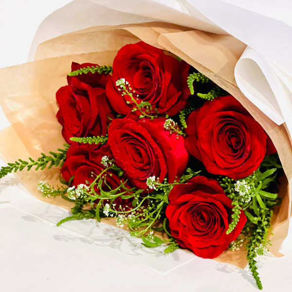Bouquet of red roses wrapped in tan paper