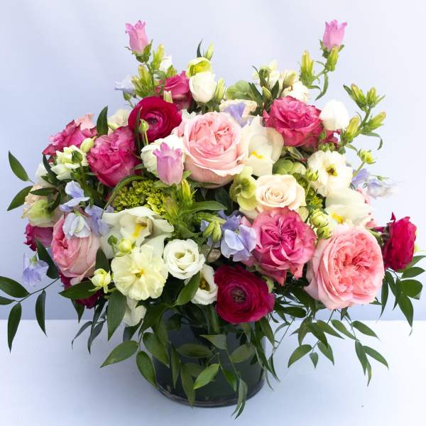 Mixed pink and white bouquet in a dark glass vase
