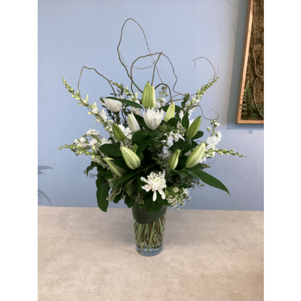 White lilies and chrysanthemums in a clear glass vase