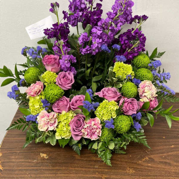 Purple and pink floral arrangement with green blooms on a table