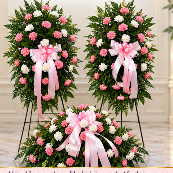 Three floral standing sprays with pink and white flowers and pink ribbons