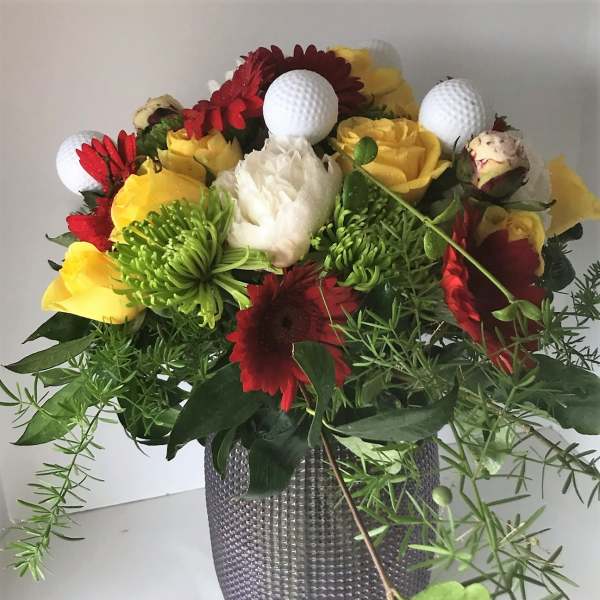 Bouquet of red, yellow, and white flowers in a textured gray vase