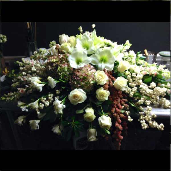 Large white floral arrangement with roses and lilies