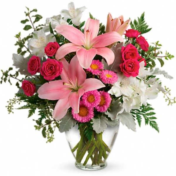 Pink lilies and roses in a clear glass vase