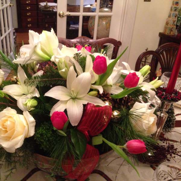 White lilies and pink tulips arranged in a low centerpiece with roses