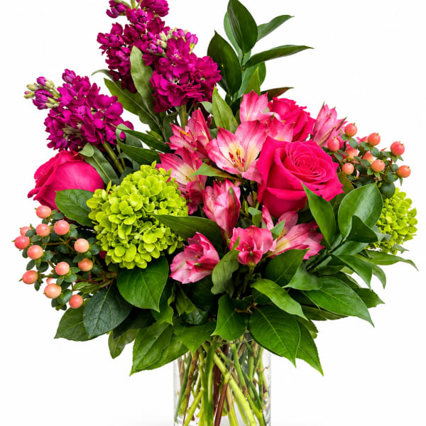 Pink and magenta flowers arranged in a clear glass vase